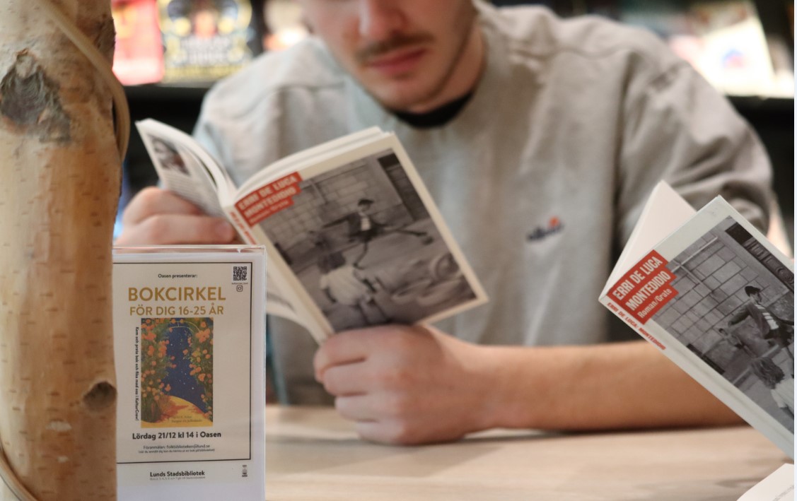 Ung man läser en bok 