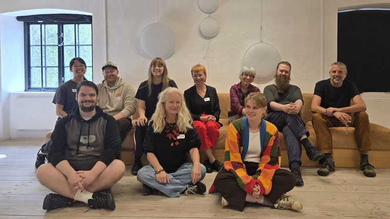 Gruppbild med tio personer som som medverkar i spelacceleratorn. De sitter i en soffa och några på golvet framför.