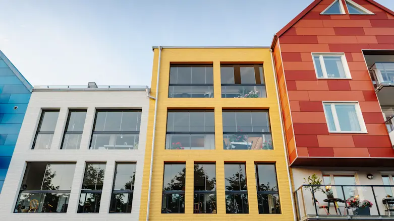 Tre färgglada bostadshus.