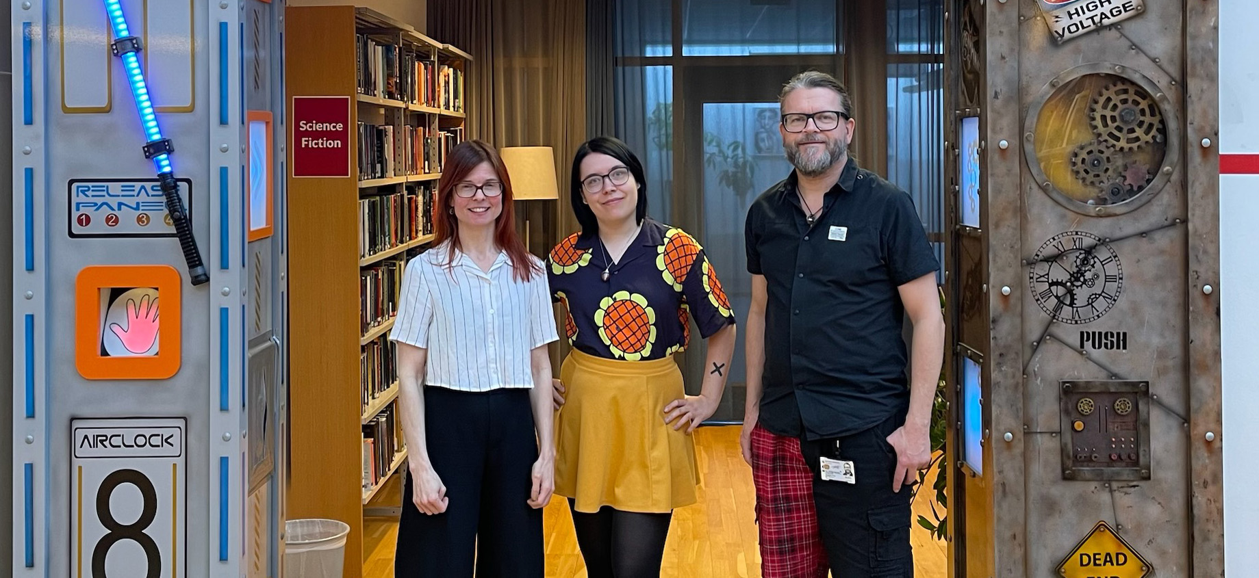 Bild på två kvinnor och en man som arbetar vid Båstads bibliotek