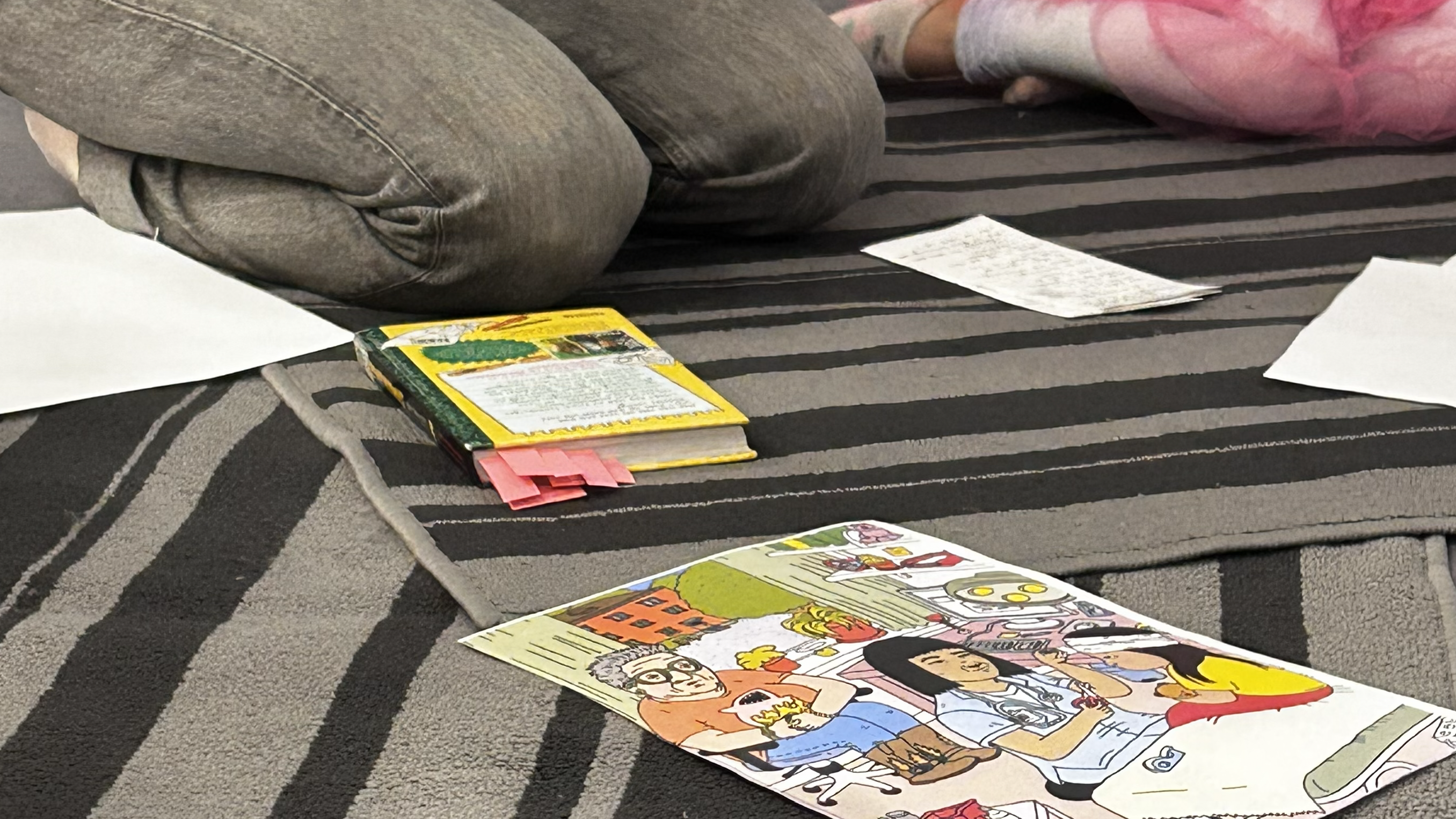 En bok och en bild ligger på ett golv. 