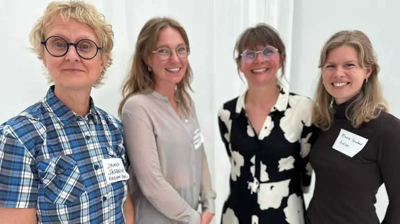 Fyra kvinnor står bredvid varandra och tittar in i kameran