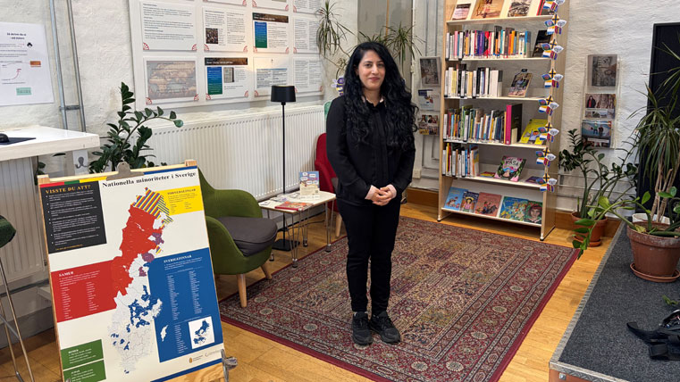 Projektledare Naghmana Toom står framför bibliotekets hörna om nationella minoriteter