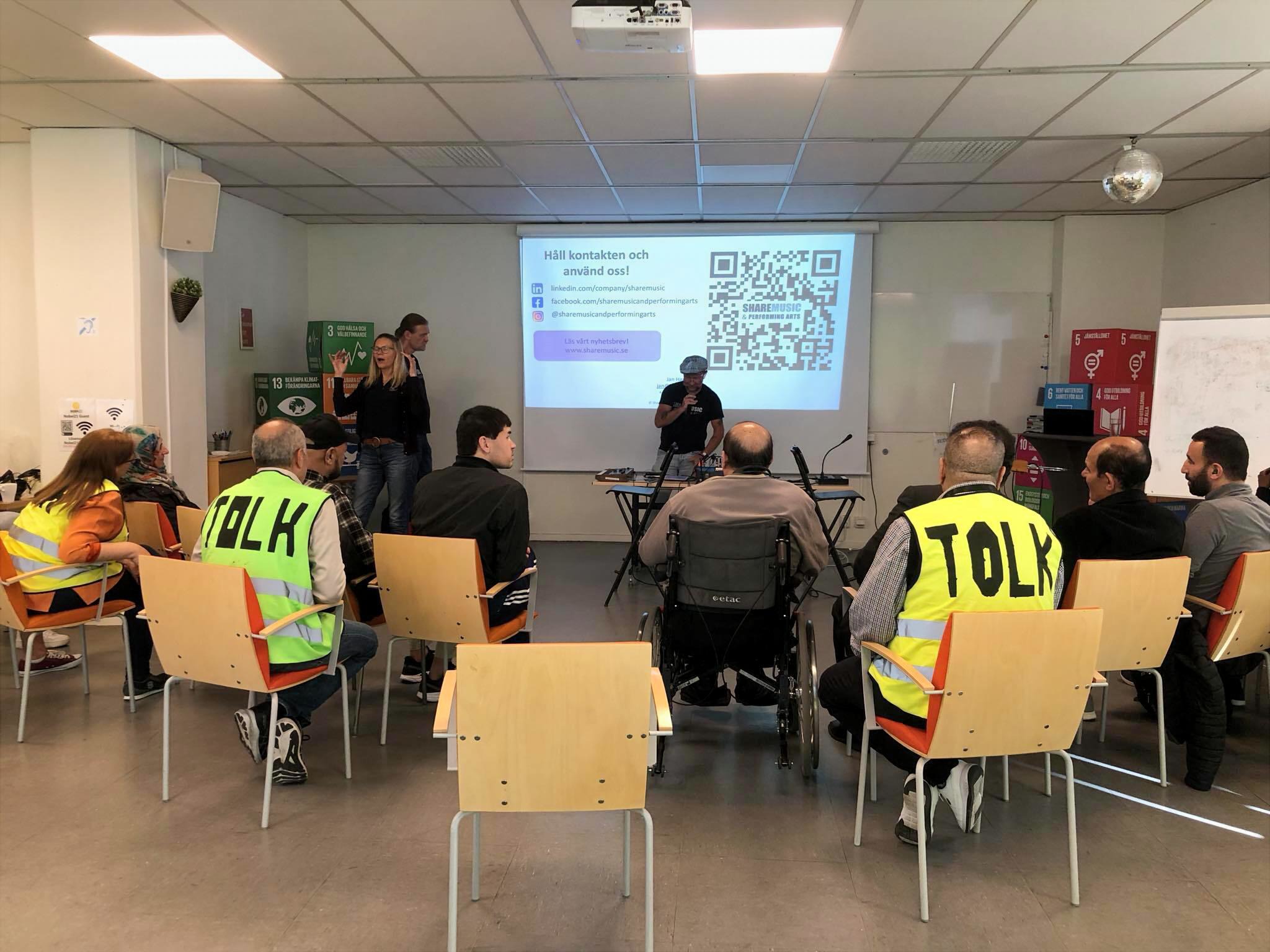 En publik lyssnar på en föreläsning som tolkas till flera språk