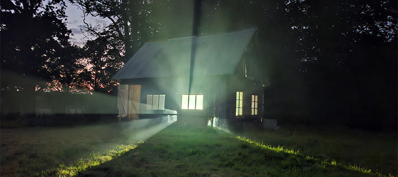 Konstinstallation med mystiskt ljus från hus.