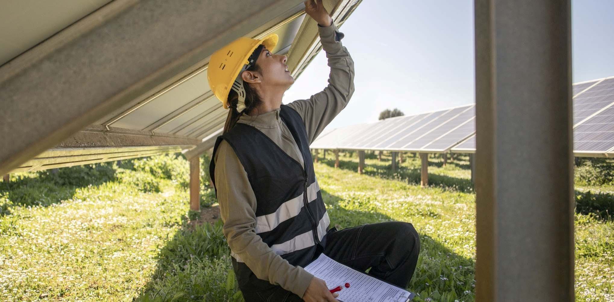 Person undersöker ett tak med solceller.