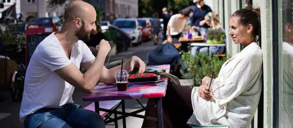 Människor som fikar utomhus i stadsmiljö.
