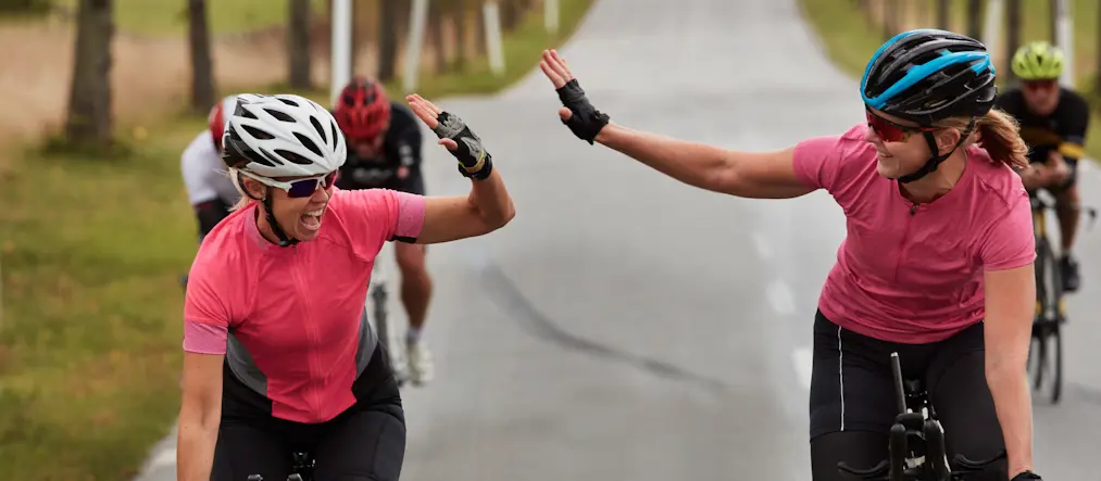 Cyklister gör high five på landsväg