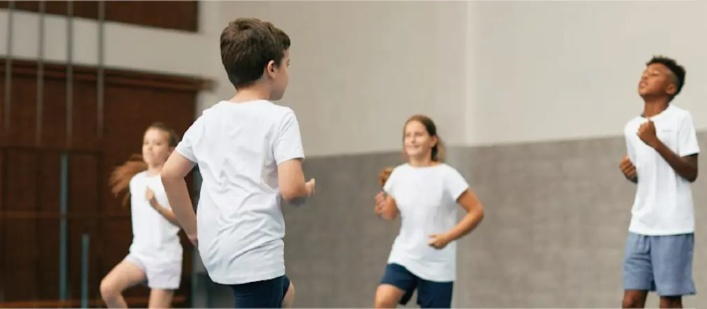 Barn som springer i en gymnastiksal.