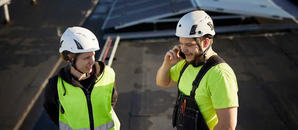 Två byggarbetare i gula västar