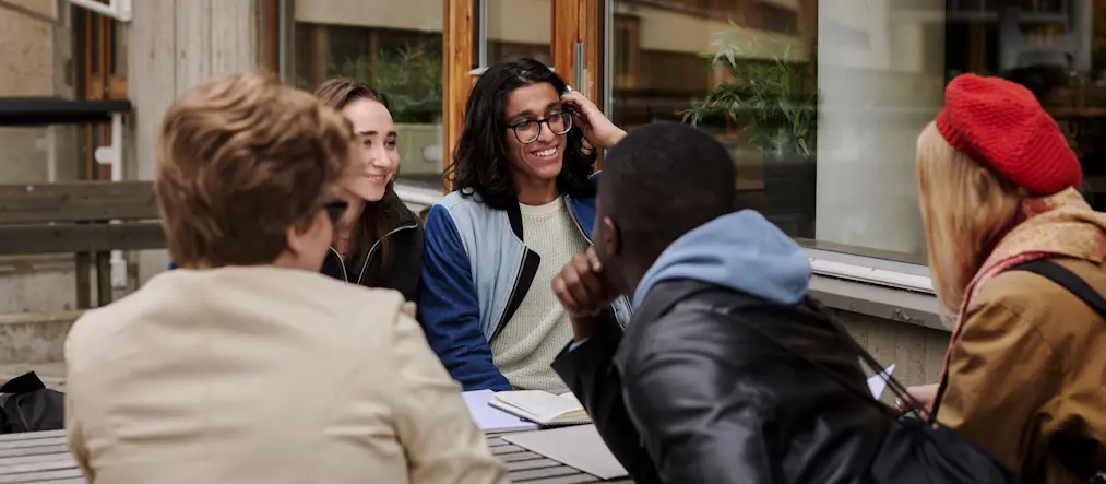 Studenter samtalar vid en bänk.