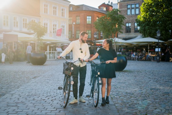 En man och en kvinna promenerar med cyklar