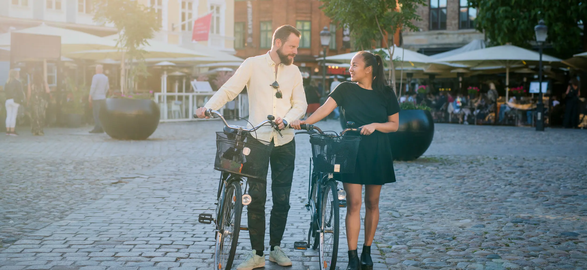 En man och en kvinna promenerar med cyklar