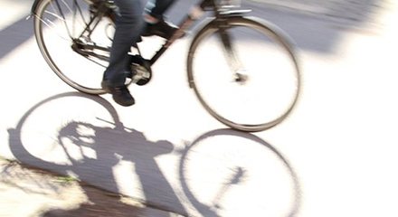 Benen och nedre delen av en cykel syns på en person som cyklar