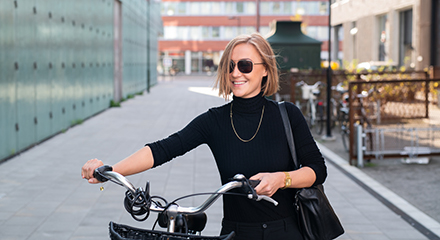 Ung kvinna leder en cykel